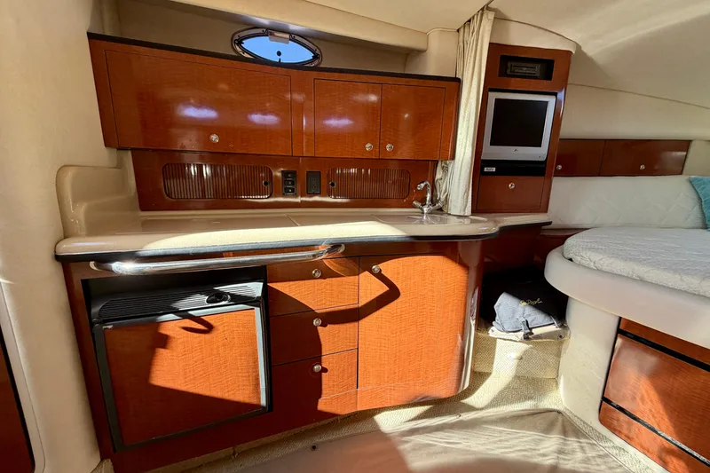 Slide: The Image of Interior of 2004 Sea Ray 320 Sundancer with kitchenette and cozy sleeping area. - 35