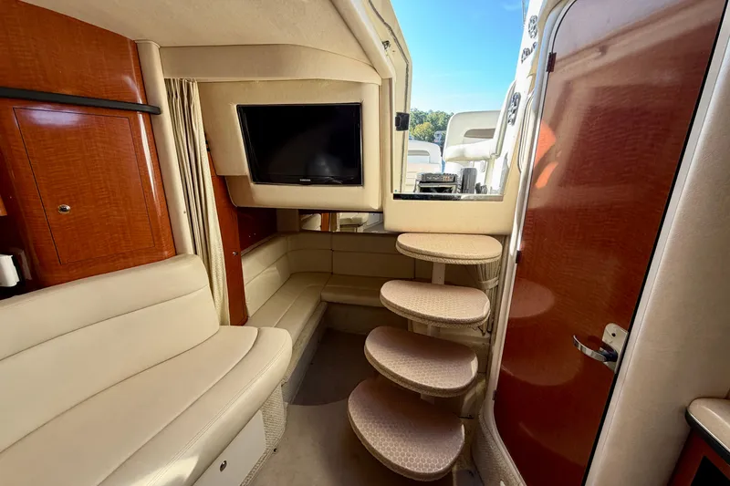 Slide: The Image of Interior of 2004 Sea Ray 320 Sundancer with seating, TV, and curved steps. - 36