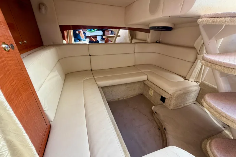 Slide: The Image of Interior of 2004 Sea Ray 320 Sundancer with beige seating and wooden accents. - 38