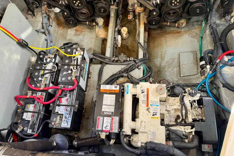 Slide: The Image of Engine compartment of a 2004 Sea Ray 320 Sundancer with batteries and mechanical components. - 46