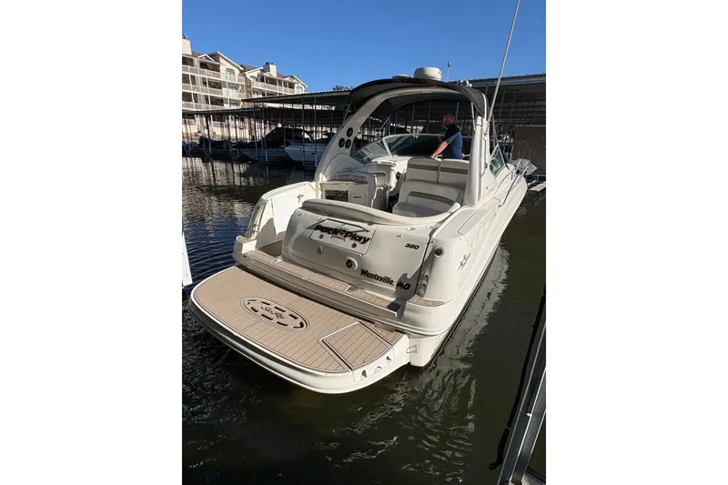 Slide: The Image of 2004 Sea Ray 320 Sundancer docked at marina, rear view with spacious deck. - 6