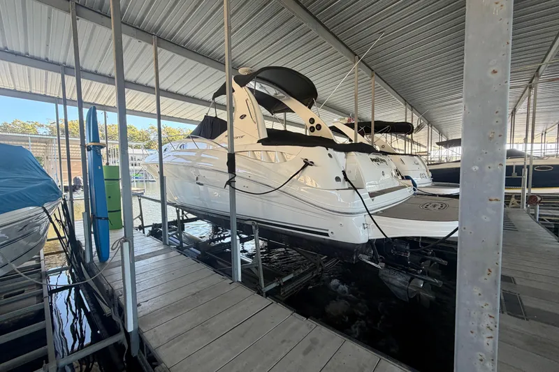 Slide: The Image of 2004 Sea Ray 320 Sundancer docked in a covered marina slip. - 7