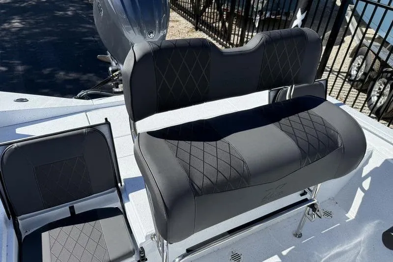 Slide: The Image of 2026 Xpress H20B Bay boat seating with diamond-stitched upholstery and motor in background. - 15