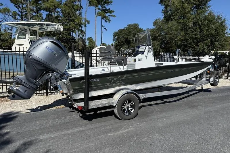 Slide: The Image of 2026 Xpress H20B Bay boat on trailer with Yamaha outboard motor, parked outdoors. - 2