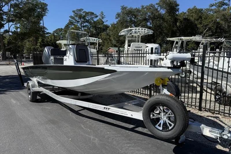 Slide: The Image of 2026 Xpress H20B Bay boat on trailer, parked outdoors near other boats. - 3