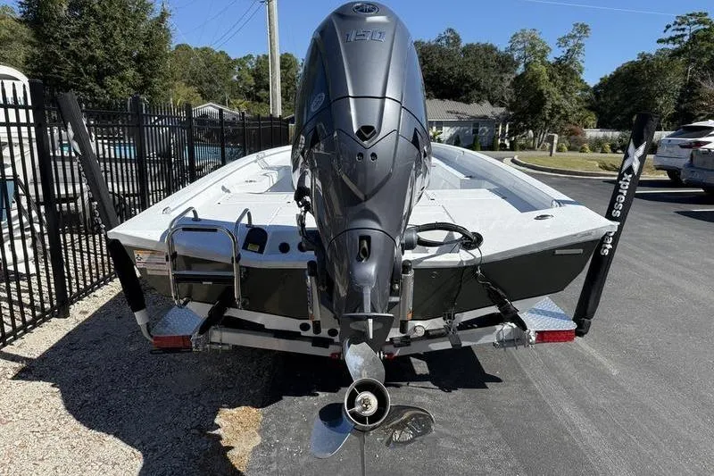 Slide: The Image of 2026 Xpress H20B Bay boat with powerful outboard motor, parked on a trailer. - 5