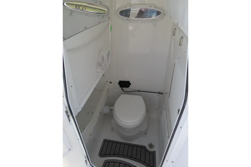 Slide: The Image of 2025 Sea Hunt Gamefish 27 boat interior with compact marine toilet and storage. - 23