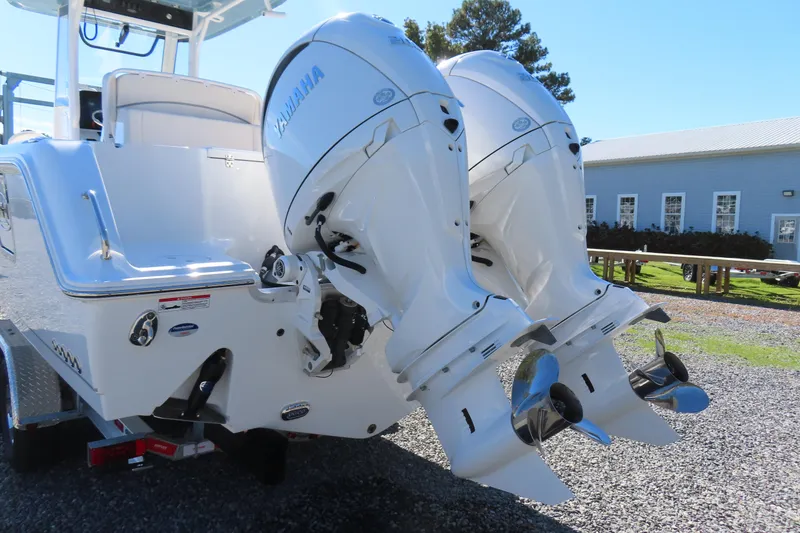 Slide: The Image of 2025 Sea Hunt Gamefish 27 boat with dual Yamaha outboard engines, parked outdoors. - 5