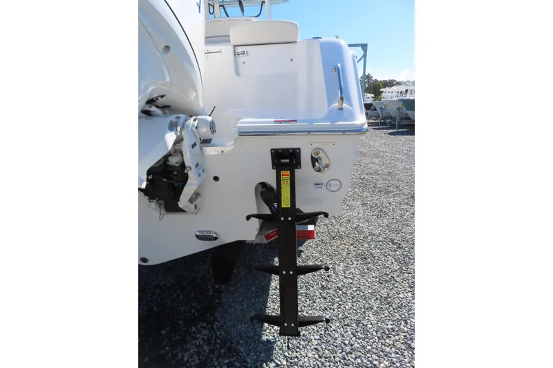 Slide: The Image of 2025 Sea Hunt Gamefish 27 boat stern with ladder on gravel surface. - 6