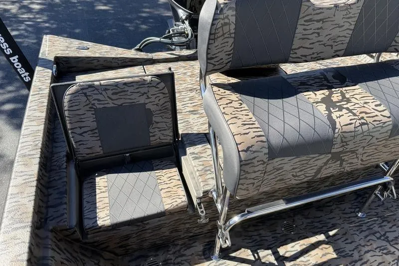 Slide: The Image of 2026 Xpress H20B Bay boat interior with camouflage seating and metal frame. - 13