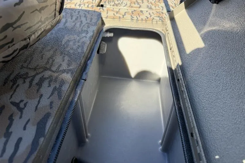 Slide: The Image of 2026 Xpress H20B Bay boat storage compartment with camo-patterned seating. - 14