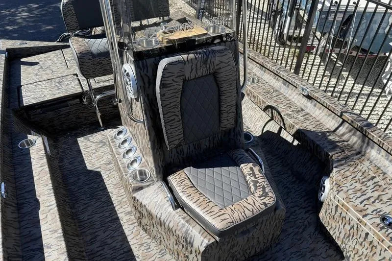Slide: The Image of 2026 Xpress H20B Bay boat interior with camo design and cushioned seating. - 8