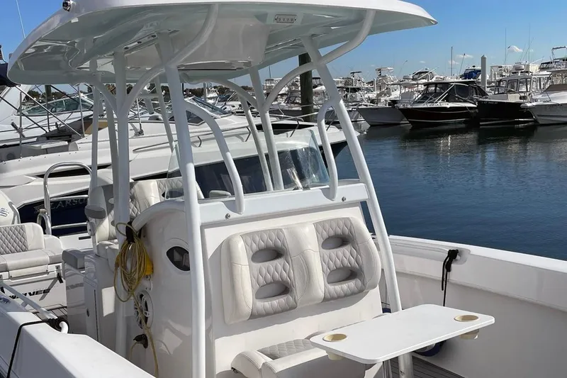 Slide: The Image of 2021 Twin Vee 260 VIVA boat with seating and console, docked at a marina. - 2