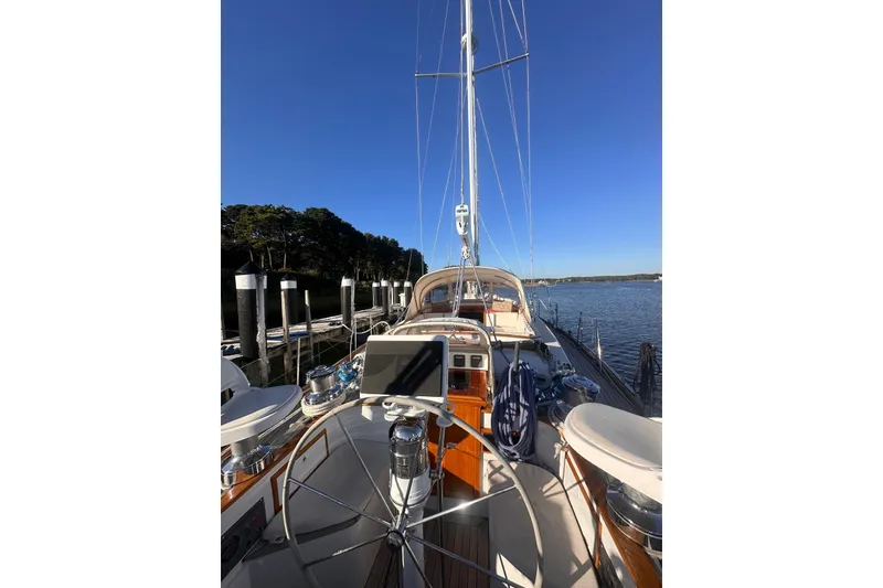 Slide: The Image of 1983 Camper & Nicholsons Cutter Rig sailboat docked, featuring a sleek deck and steering wheel. - 11