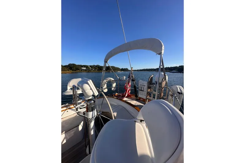 Slide: The Image of 1983 Camper & Nicholsons Cutter Rig sailboat on calm water under clear blue sky. - 12