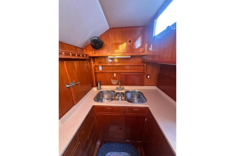 Slide: The Image of 1983 Camper & Nicholsons Cutter Rig kitchen with wooden cabinetry and dual sink. - 19
