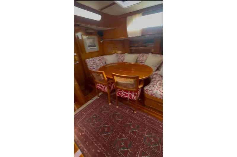 Slide: The Image of Interior of 1983 Camper & Nicholsons Cutter Rig with wooden dining area and patterned cushions. - 21