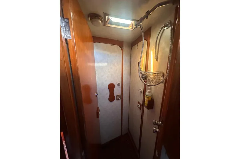 Slide: The Image of 1983 Camper & Nicholsons Cutter Rig interior shower with wooden accents and overhead light. - 27