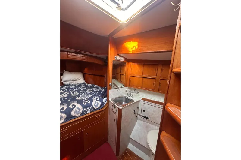 Slide: The Image of 1983 Camper & Nicholsons Cutter Rig interior with cozy bed, compact kitchen, and wooden cabinetry. - 29