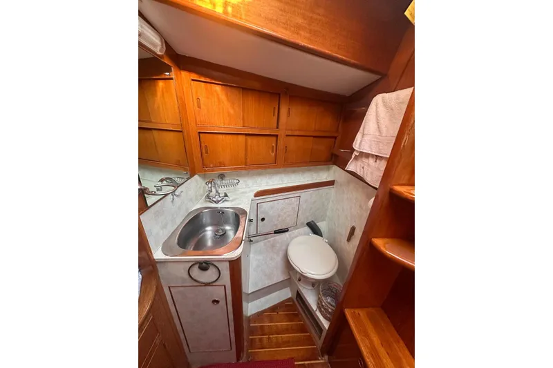 Slide: The Image of Interior of 1983 Camper & Nicholsons Cutter Rig, featuring compact bathroom with sink and toilet. - 31