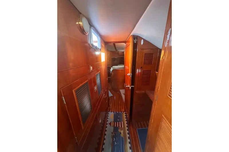 Slide: The Image of Interior of 1983 Camper & Nicholsons Cutter Rig, featuring wooden paneling and nautical decor. - 32