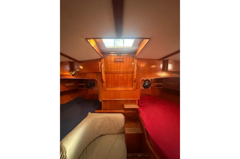 Slide: The Image of Interior of 1983 Camper & Nicholsons Cutter Rig, featuring wooden paneling and cozy sleeping area. - 34