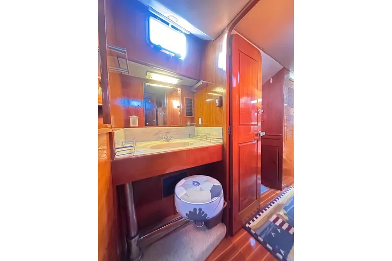 Slide: The Image of Interior of 1983 Camper & Nicholsons Cutter Rig, featuring a wooden bathroom with sink and mirror. - 38