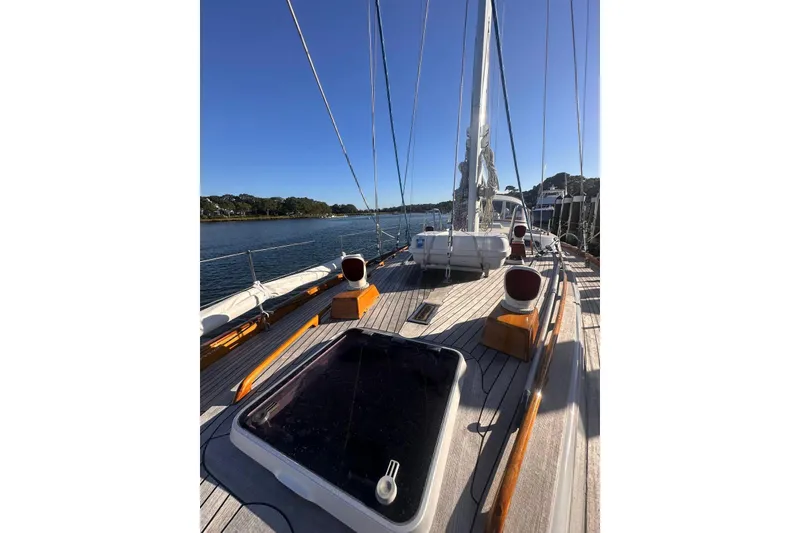 Slide: The Image of 1983 Camper & Nicholsons Cutter Rig sailboat deck with clear blue sky and waterfront view. - 7