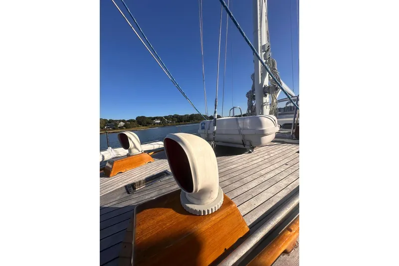 Slide: The Image of 1983 Camper & Nicholsons Cutter Rig deck with lifeboat and vents, under clear blue sky. - 8