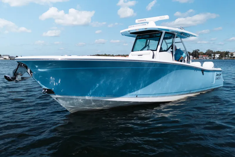 The Image of 2021 Blackfin 332 CC boat on calm water under a clear blue sky. - 0