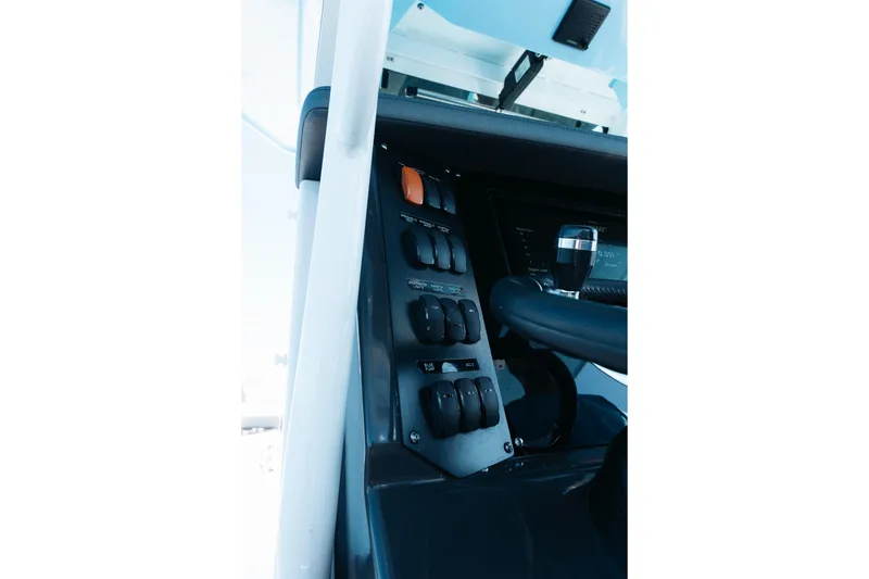 Slide: The Image of 2021 Blackfin 332 CC boat dashboard with control switches and steering wheel. - 10
