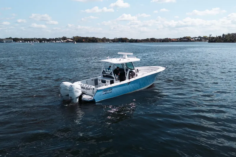 Slide: The Image of 2021 Blackfin 332 CC boat on calm water under a clear sky. - 100