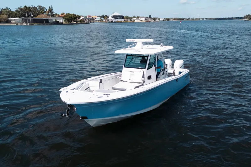 Slide: The Image of 2021 Blackfin 332 CC boat on calm water, featuring a sleek blue and white design. - 101