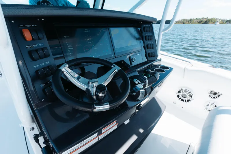 Slide: The Image of 2021 Blackfin 332 CC boat dashboard with steering wheel and navigation controls. - 13