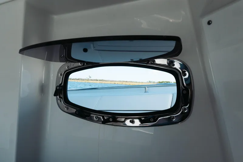 Slide: The Image of Porthole view from 2021 Blackfin 332 CC boat, overlooking serene water and distant shoreline. - 24