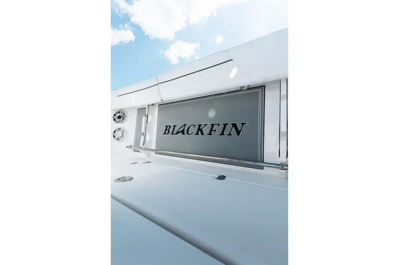 Slide: The Image of 2021 Blackfin 332 CC boat with sleek design and logo under blue sky. - 26