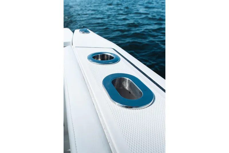 Slide: The Image of 2021 Blackfin 332 CC boat detail with cup holders, ocean background. - 28