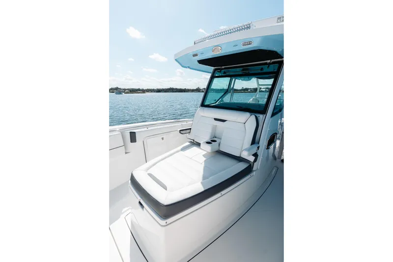 Slide: The Image of 2021 Blackfin 332 CC boat interior with white seating, cup holders, and ocean view. - 30
