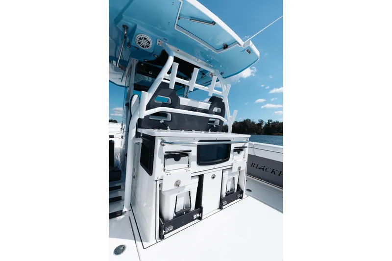 Slide: The Image of 2021 Blackfin 332 CC boat interior with storage and seating, under a clear blue sky. - 38