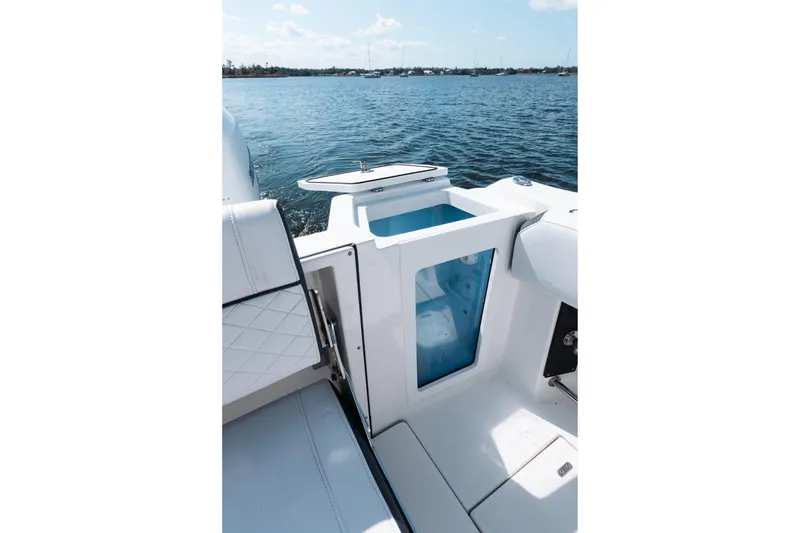 Slide: The Image of 2021 Blackfin 332 CC boat interior with seating and storage, overlooking calm waters. - 46