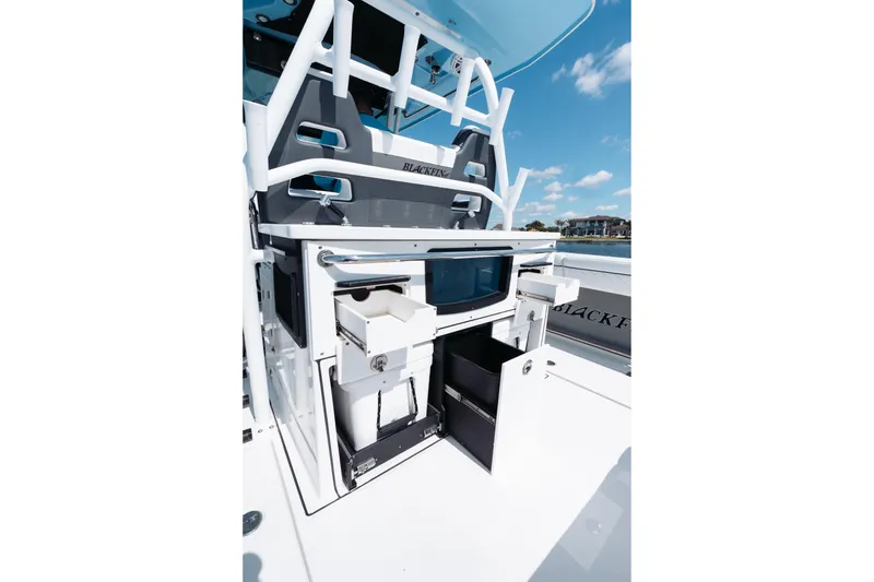 Slide: The Image of 2021 Blackfin 332 CC boat interior with storage compartments and seating, under a clear blue sky. - 48