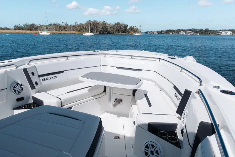 Slide: The Image of 2021 Blackfin 332 CC boat interior with seating and table on calm water. - 53