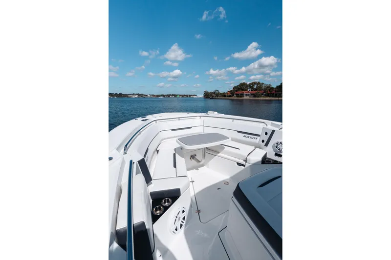 Slide: The Image of 2021 Blackfin 332 CC boat interior with seating and table on a sunny day. - 54