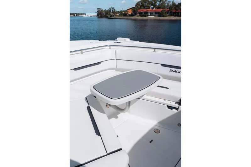 Slide: The Image of 2021 Blackfin 332 CC boat interior with seating and table, near calm water. - 55