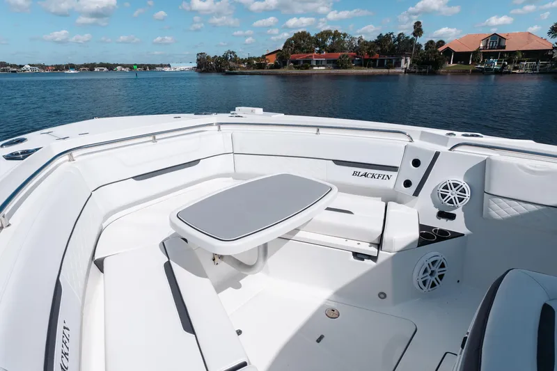 Slide: The Image of 2021 Blackfin 332 CC boat interior with seating and table on a sunny day. - 56