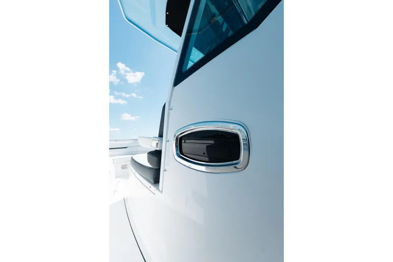 Slide: The Image of 2021 Blackfin 332 CC boat detail with sleek design and chrome accents under blue sky. - 6