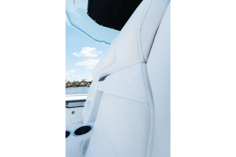 Slide: The Image of 2021 Blackfin 332 CC boat interior with white leather seating and cup holders. - 63