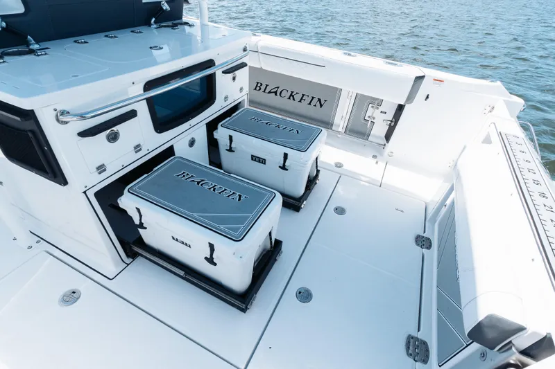 Slide: The Image of 2021 Blackfin 332 CC boat deck with storage compartments and coolers on the water. - 74