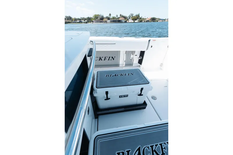 Slide: The Image of 2021 Blackfin 332 CC boat with Yeti cooler on deck, overlooking serene water. - 75