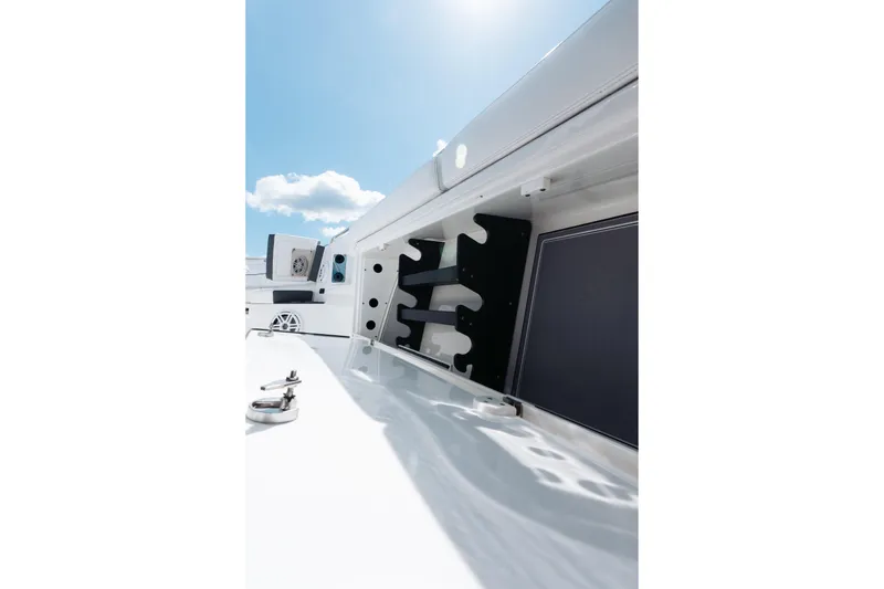 Slide: The Image of 2021 Blackfin 332 CC boat interior detail with rod holders under clear blue sky. - 80